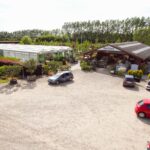 Parkeringsplads foran planteskolens butik og drivhus set oppefra
